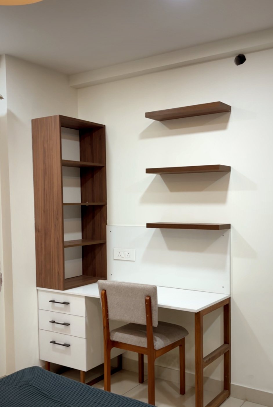 Study corner with a bookshelf, floating wall shelves and a custom desk