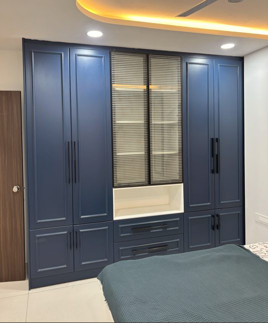 Blue fitted wardrobe with fluted glass display shutters